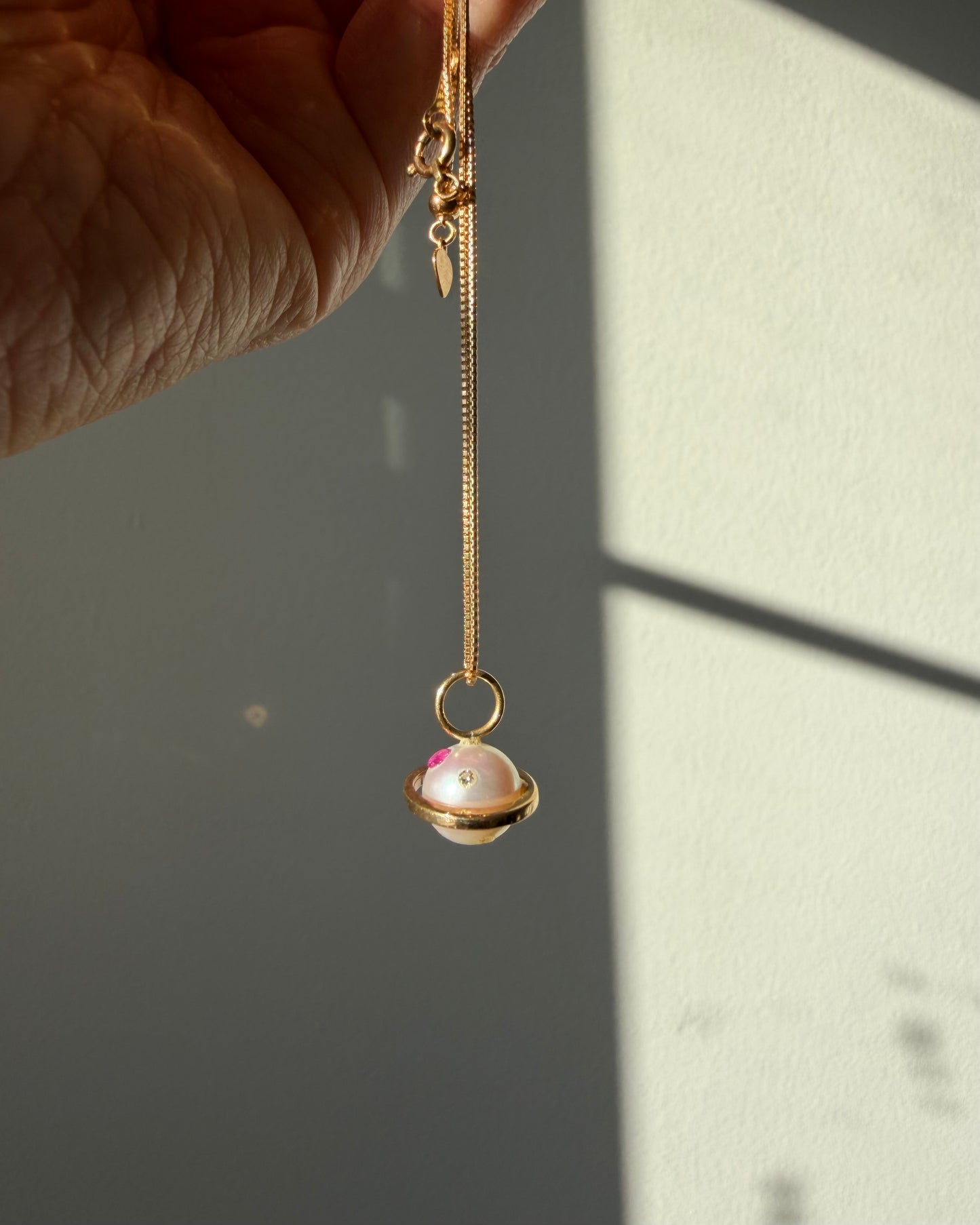 Modern Pre-loved 18k Gold Pearl with Flush Set Ruby and Diamond Saturn Pendant Necklace