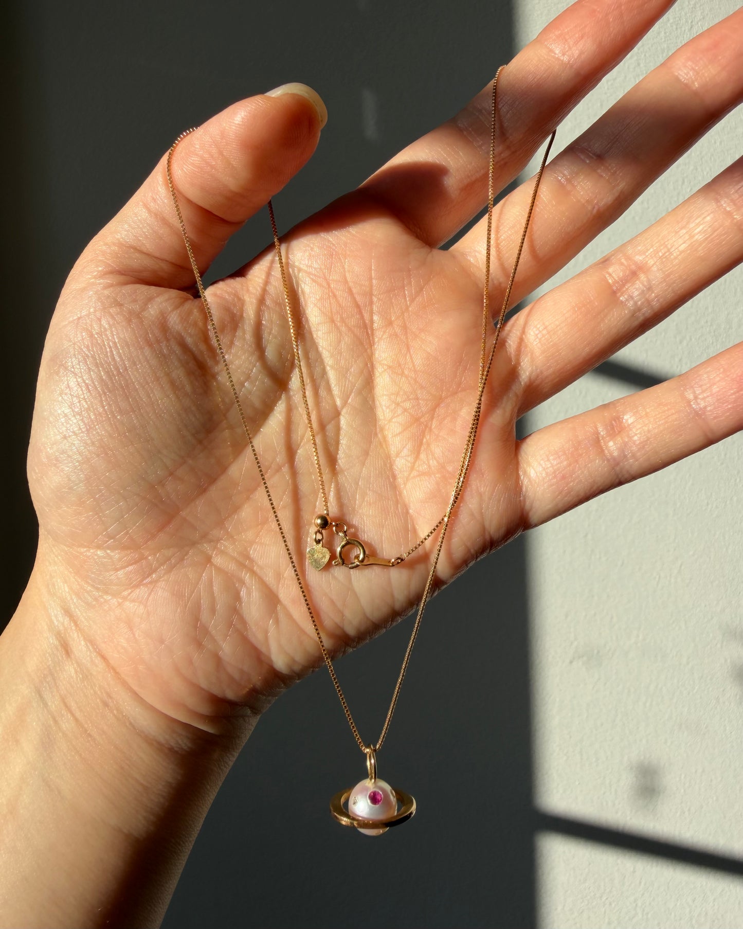 Modern Pre-loved 18k Gold Pearl with Flush Set Ruby and Diamond Saturn Pendant Necklace