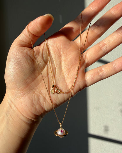 Modern Pre-loved 18k Gold Pearl with Flush Set Ruby and Diamond Saturn Pendant Necklace